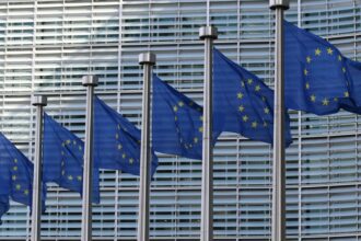 Bandeira da União Europeia com símbolos de criptomoedas